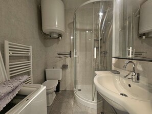Une salle de bain moderne avec une douche à parois de verre, des toilettes et un lavabo.