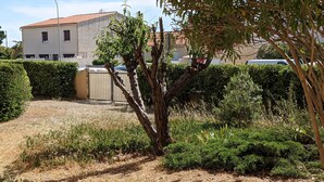 A residential area with a paved driveway leading to a building with a tiled roof. - Charming Ground-Floor T2 Apartment, 300m from Beach, Port View, Parking Included, Sleeps 4. (Port-la-Nouvelle)