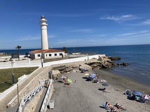 A coastal area with a lighthouse, beach, and rocky shoreline. - New apartment in Torrox Costa, 20m from the beach, air conditioning, Wi-Fi (Torrox Costa)