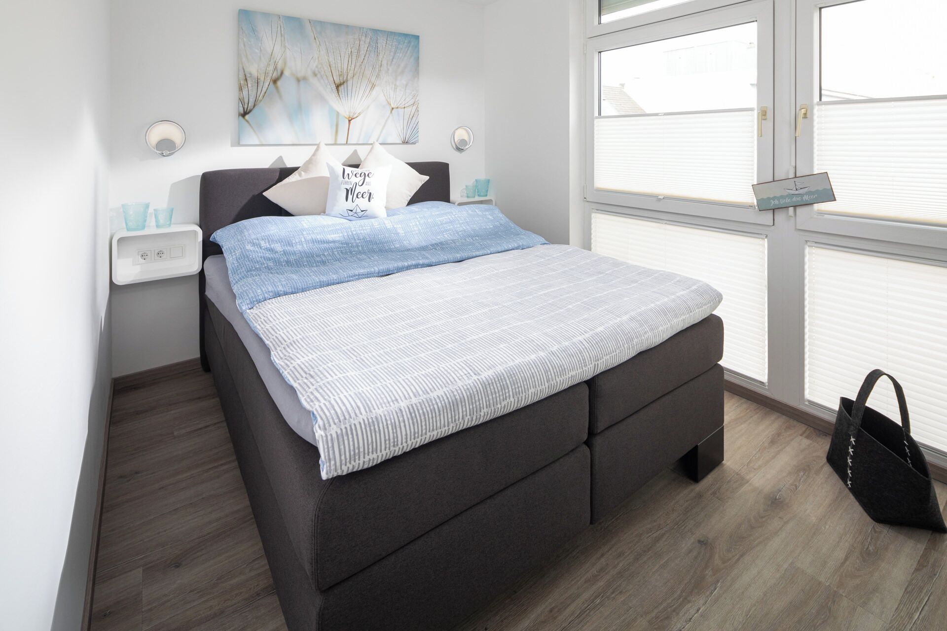 Quarto moderno com cama, janela e uma obra de arte na parede.