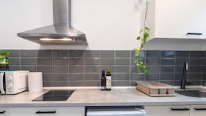 Une cuisine moderne équipée d’un four encastré, d’un lave-vaisselle et d’une hotte en acier inoxydable.