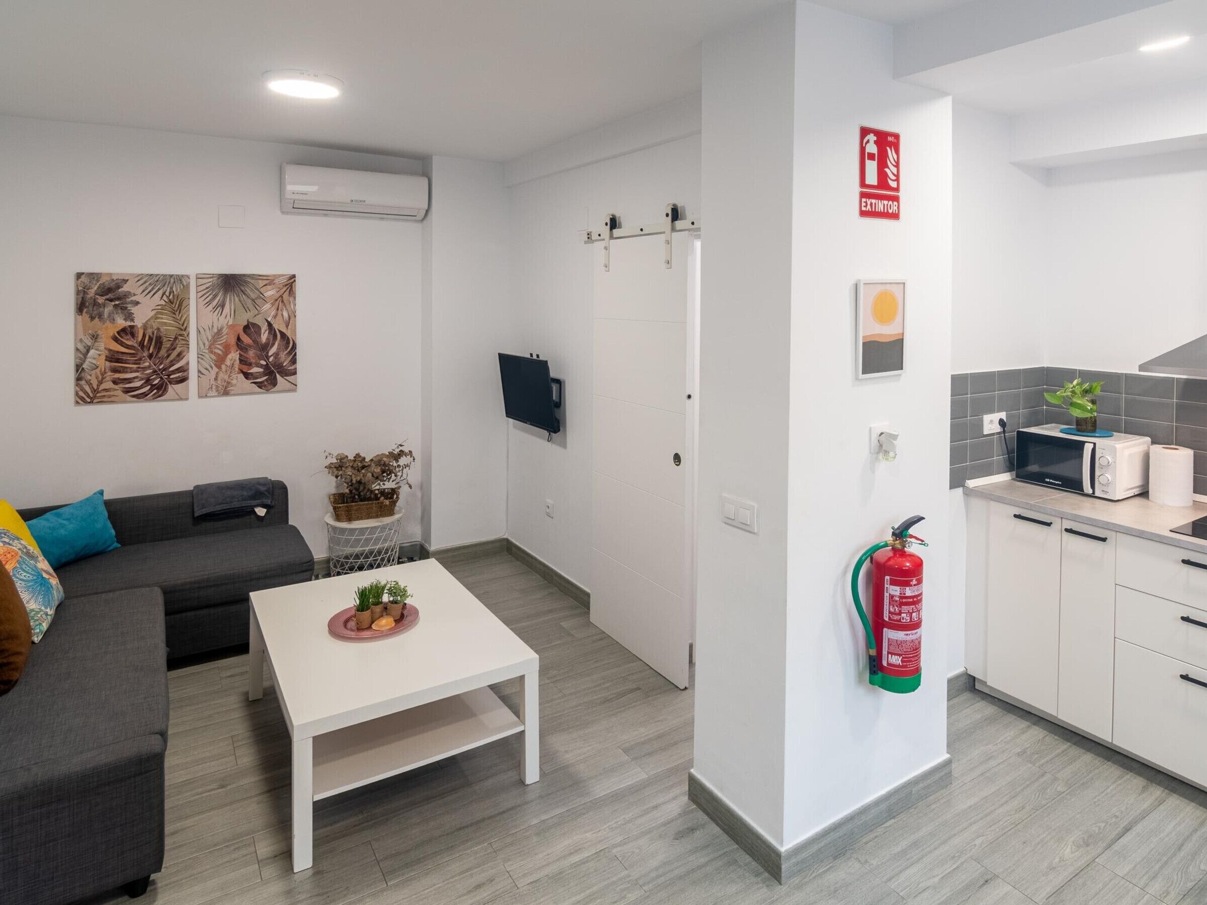 Una sala de estar moderna con un sofá, una mesa de centro y obras de arte en la pared.