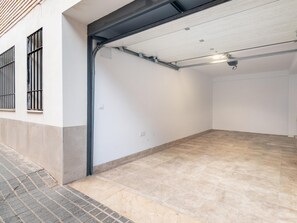 A clean, empty garage with a tiled floor and a metal garage door.