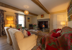A cozy living room with a fireplace, a sofa, a television, and a coffee table.