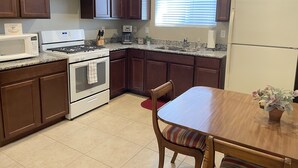 A kitchen with dark brown cabinets, a white stove, a microwave, a sink, and a refrigerator. - Windtree Hideaway! Trees, hiking, minutes downtown (Flagstaff)