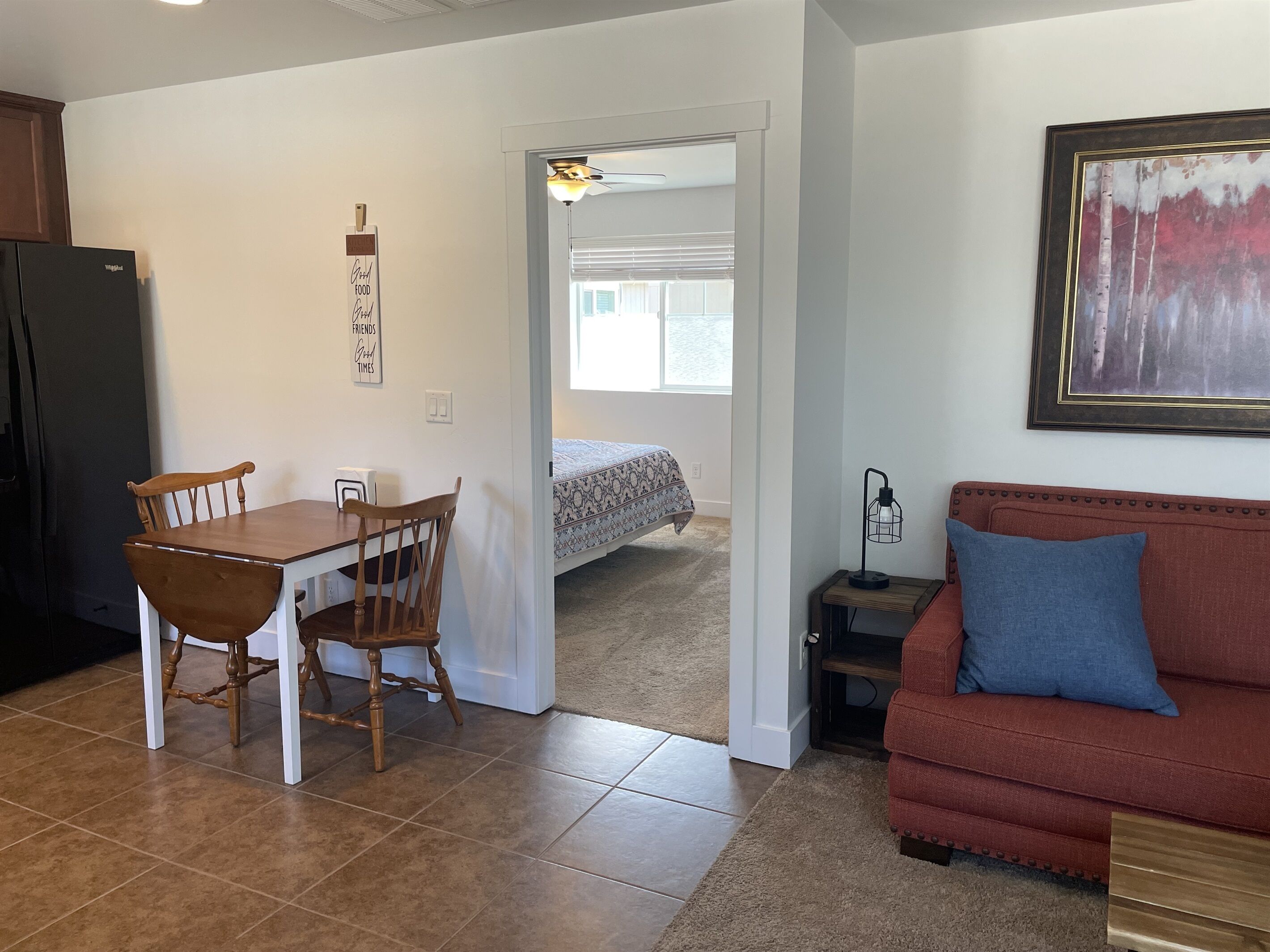 Un espace de vie compact comprenant un coin repas, une kitchenette, un canapé et un lit.