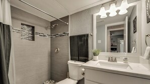 A modern bathroom with a shower, toilet, and sink. - I48-1 - Apt|Patio|11mi to Convention Ctr|Sleeps 2 (Irving)