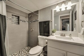 A modern bathroom with a shower, toilet, and sink. - I48-1 - Apt|Patio|11mi to Convention Ctr|Sleeps 2 (Irving)