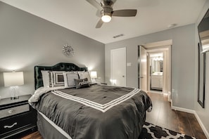 A bedroom with a large bed, two bedside tables with lamps, a ceiling fan, and a door leading to another room. - I48-1 - Apt|Patio|11mi to Convention Ctr|Sleeps 2 (Irving)