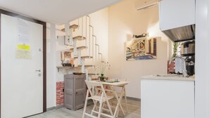 Eine kompakte Küche mit Essbereich, Kühlschrank, Spüle und Herd.