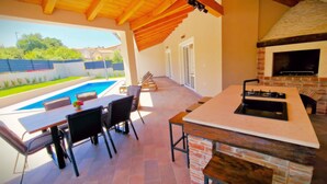A patio with a pool, outdoor seating, and a brick oven. - A picturesque holiday home, located in a quiet part of the Rovinj municipality (Rovinjsko Selo)
