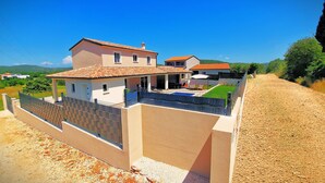 A two-story house with a swimming pool, a fenced patio, and a dirt road. - A picturesque holiday home, located in a quiet part of the Rovinj municipality (Rovinjsko Selo)