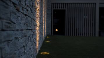 Um muro de pedra com um caminho estreito que leva à entrada de um edifício.