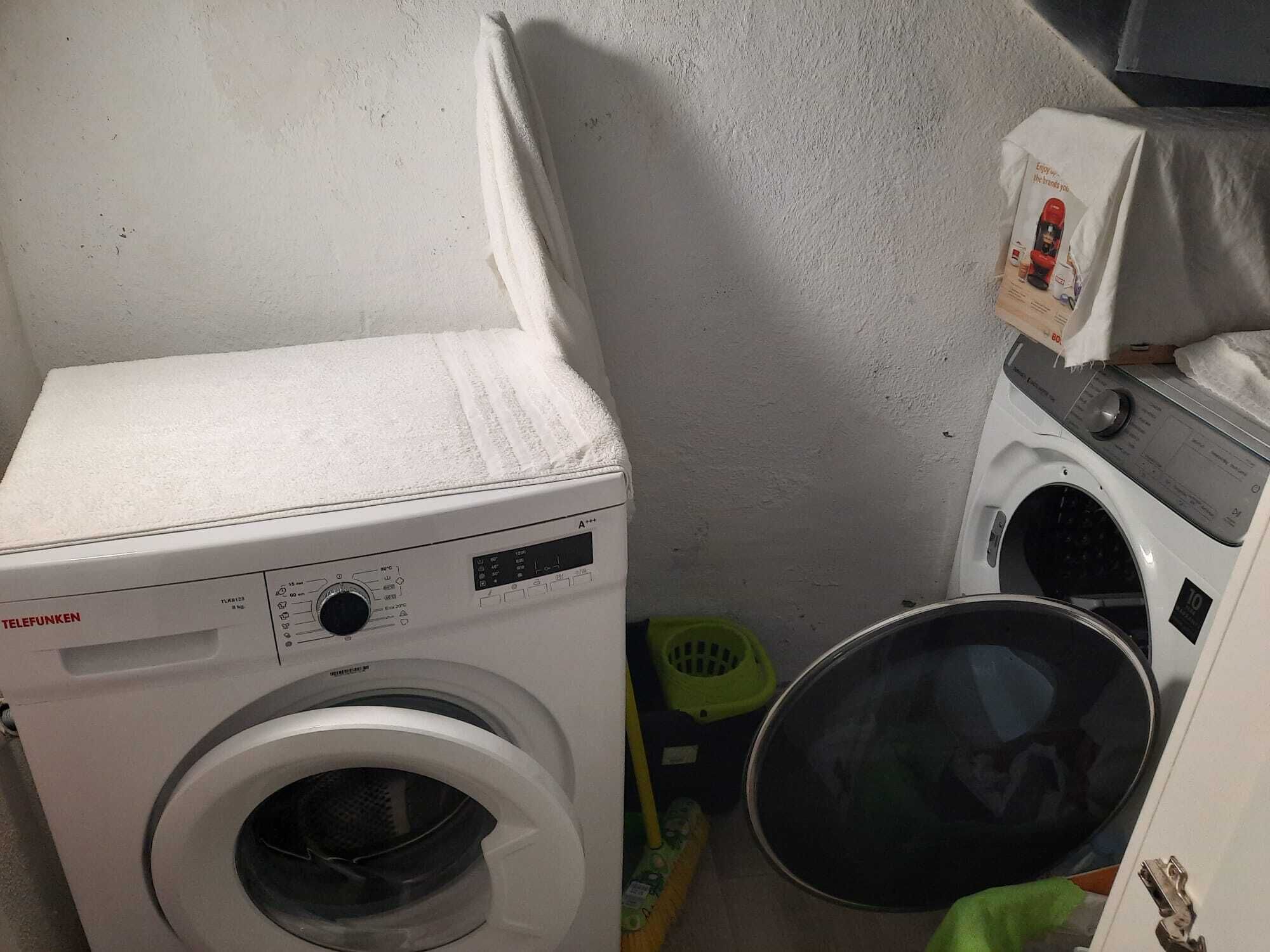 A compact laundry area with a front-loading washing machine and a stacked dryer.