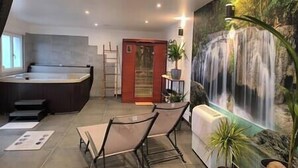 Zona de spa con hidromasaje, asientos y un mural de cascada.
