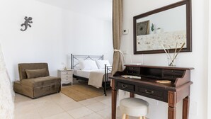 Une chambre à coucher avec un lit, un bureau, une chaise et un canapé.