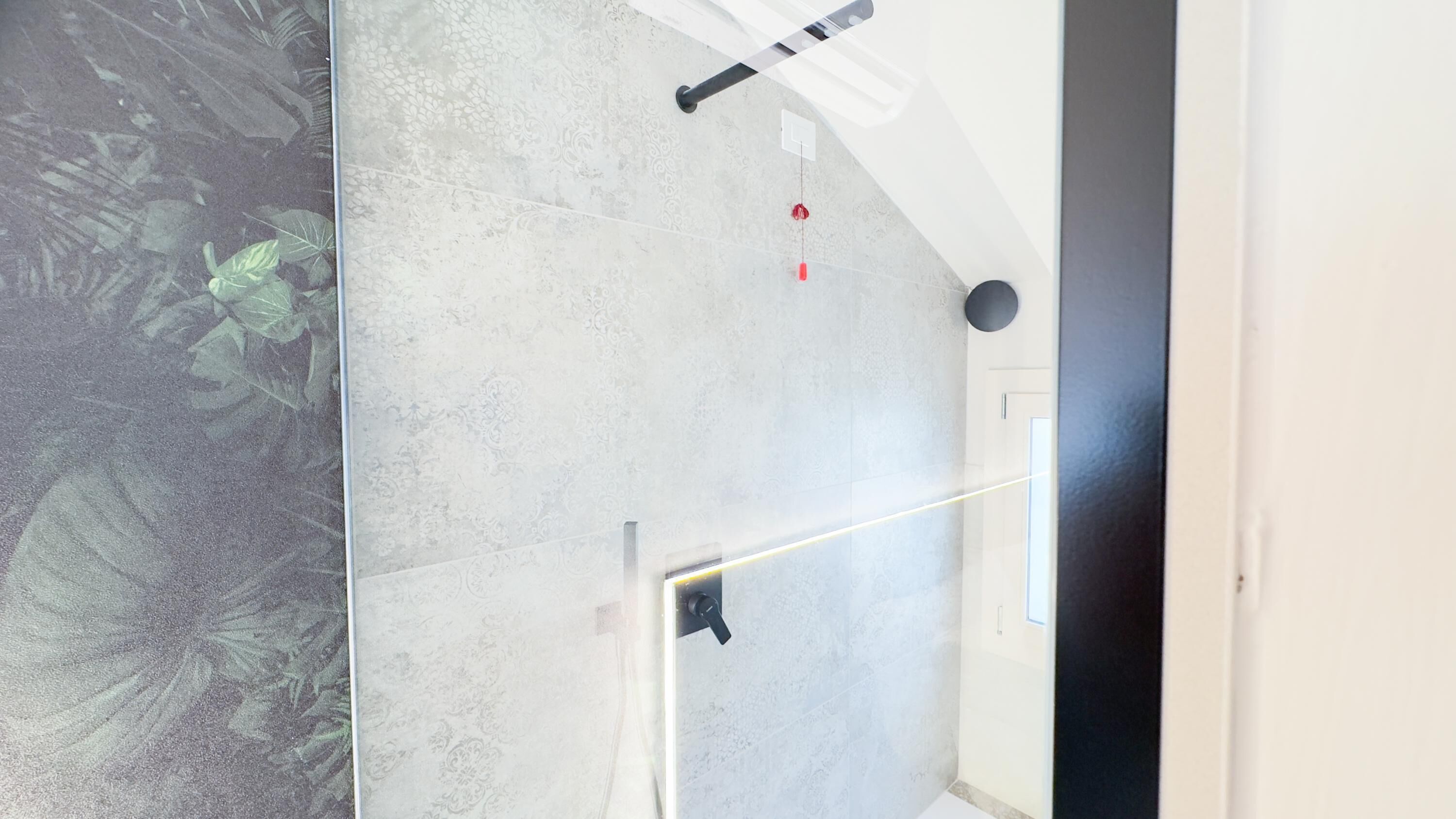Een modern interieur met een betonnen vloer, een zichtbare deur en een plafond met een lamp.