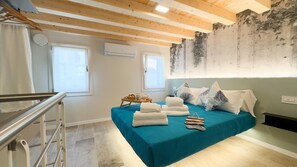 A bedroom with a teal bedspread, a wooden ceiling, and a concrete wall with a mural. - Graceful Apartments Paradise by Ca-sa Check (Chioggia)