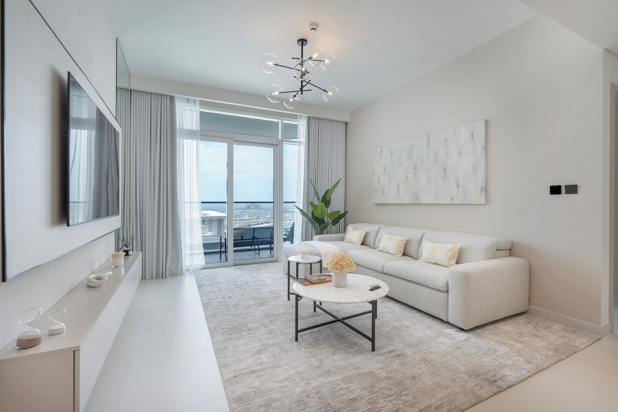 A modern living room with a sofa, coffee table, and a large window with curtains.
