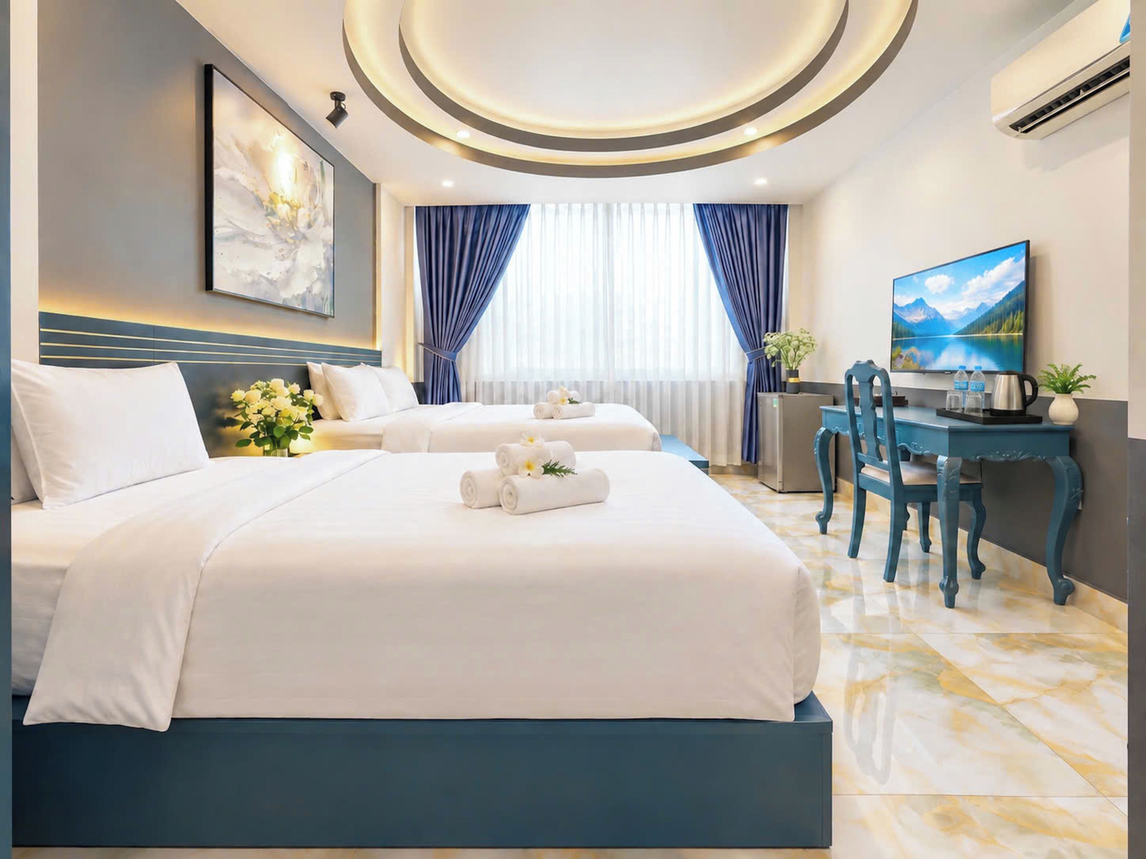 A hotel room with two beds, a desk, a chair, a television, and a painting on the wall.