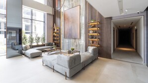 A modern living room with a large sectional sofa, a coffee table, and a bookshelf.