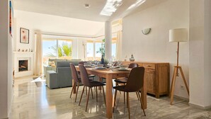 A spacious living area with a dining table, chairs, and a sofa. - 3 bedroom penthouse apartment in Calahonda (Mijas Costa)