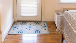 A room with a door, a radiator, a window with blinds, and a patterned rug. - Walk to Downtown, Parking, King Bed, Patios (Eureka Springs)