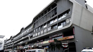 A multi-story building with various shops on the ground floor, including a hotel and a bus stop. - Hotel Rio Orbit (Rajkot)