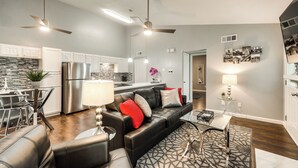 A modern living room with a black leather sofa, a glass coffee table, and a patterned rug. - I54-1 - Apt|Patio|11mi to Convention Ctr|Sleeps 2 (Irving)