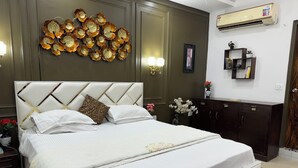 A neatly made bed with a white headboard and decorative wall art above it.