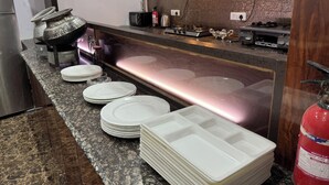 A kitchen with a stainless steel counter, a fire extinguisher, and a microwave.
