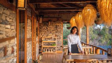 Un interior rústico de madera con paredes de piedra, muebles de madera y lámparas colgantes.
