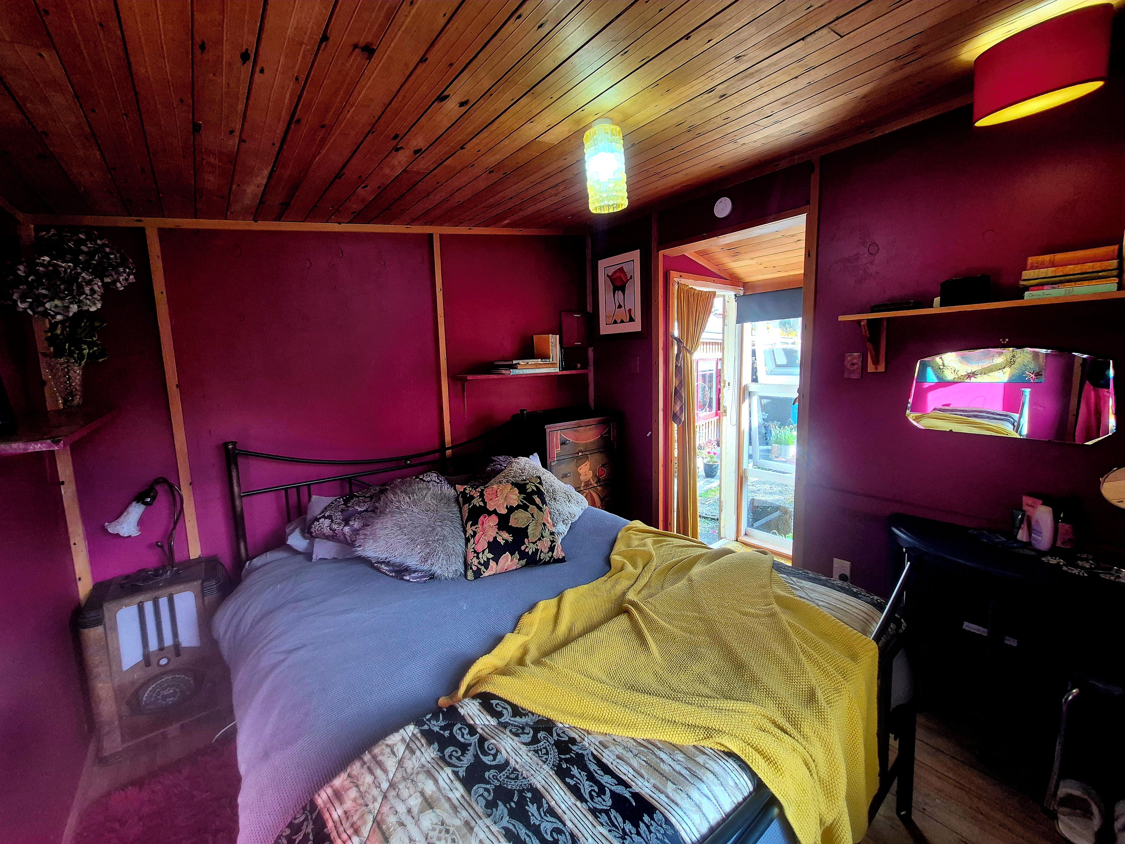 Una habitación con cama, escritorio y ventana.