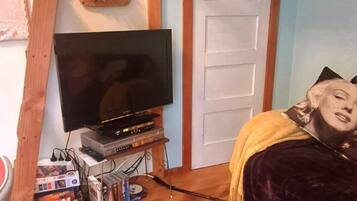Ein Wohnzimmer mit Fernseher, Plattenspieler und einer Couch.