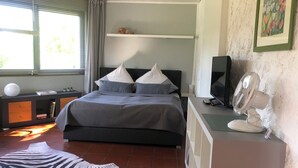A bedroom with a bed, a desk, a chair, a zebra rug, a fan, and a picture on the wall. - Urlaub Inmitten der Natur (Mechernich)