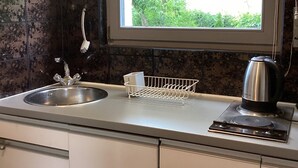 A kitchen with a window, a sink, a kettle, and a clock. - Urlaub Inmitten der Natur (Mechernich)