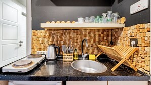A kitchen with a black countertop, stainless steel sink, and a wooden rack holding corks. - Cozy Central Flat w/Netflix & Elevator Near Metro 2 minute walking distance (İstanbul)