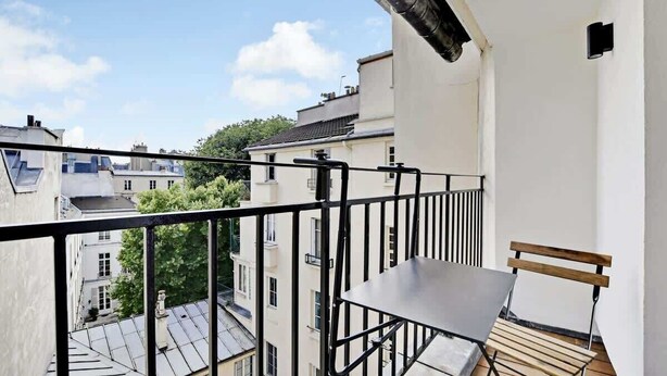 A balcony with a metal railing, a wooden bench, and a metal table. - A Glorious 2-Ch/2SdB w/ Services in Saint-Germain (Paris)