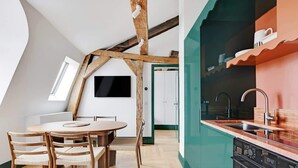 A modern kitchen with a built-in oven and a dining area with a wooden table and chairs. - A Glorious 2-Ch/2SdB w/ Services in Saint-Germain (Paris)