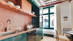 A modern kitchen with a glass backsplash, stainless steel appliances, and a dining area with a table and chairs.