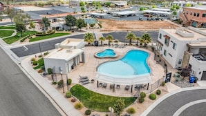 Zona residencial com uma grande piscina, edifícios modernos e paisagismo bem cuidado.