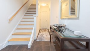 A staircase with wooden steps and a handrail, leading to a door at the top.
