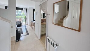 A modern interior with a dining area, a large mirror, and a radiator. - Casa Mila Roda Sleeps 4 With Pool (San Javier)