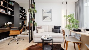 Een moderne woonkamer met een bank, een salontafel, een bureau en een boekenkast.