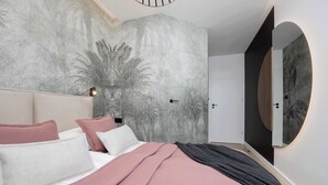 Een moderne slaapkamer met een groot bed, een wandspiegel en een wanddecoratie met reliëf.