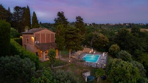 A villa with a swimming pool, surrounded by lush greenery and a scenic view. - Villa Frantusina Volterra (Volterra)