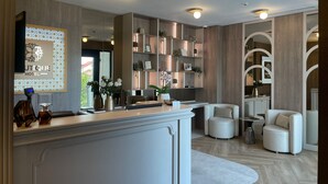Eine moderne Hotelhalle mit Empfangsschalter, Sitzgelegenheiten und dekorativen Regalen.