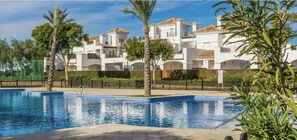 A swimming pool with a white building in the background. - Golf Resort - Apartment - Sleeps4 - Pool - Parking (Torre-Pacheco)