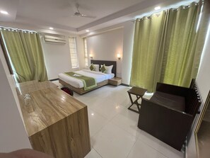 Habitació d'hotel moderna amb un llit, una taula de treball i zona de seients.