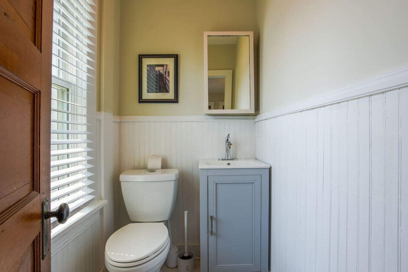 Ein Badezimmer mit Toilette, Waschbecken und Spiegel.